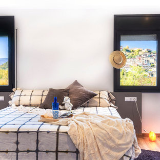Foto de habitación de invitados actual con paredes blancas, suelo de corcho y suelo marrón