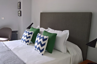 Diseño de dormitorio principal escandinavo grande con suelo de madera en tonos medios y paredes grises