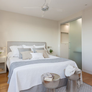Foto de dormitorio principal, costero, sin chimenea, con paredes beige y suelo de madera en tonos medios