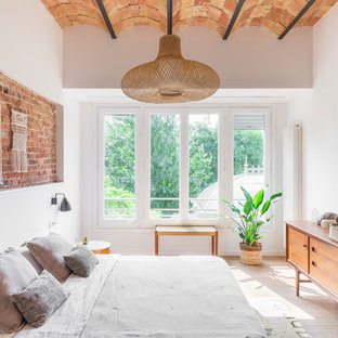 Foto de dormitorio mediterráneo, sin chimenea, con paredes blancas, suelo de madera clara y suelo beige