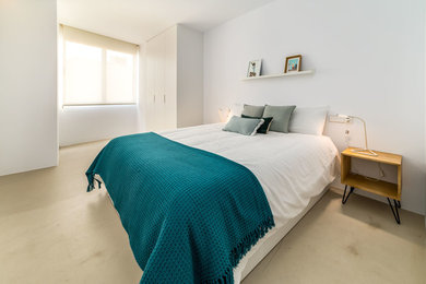 Modelo de habitación de invitados mediterránea con paredes blancas, suelo de cemento y suelo beige