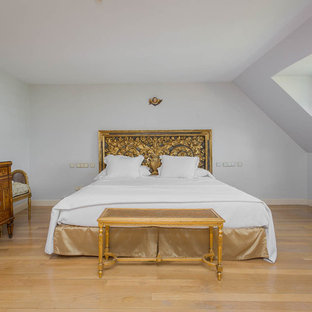 Foto de dormitorio principal, clásico, de tamaño medio, con paredes blancas, suelo de madera clara y suelo beige