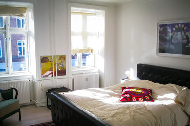 Diseño de dormitorio principal clásico renovado de tamaño medio sin chimenea con paredes blancas y suelo de madera en tonos medios