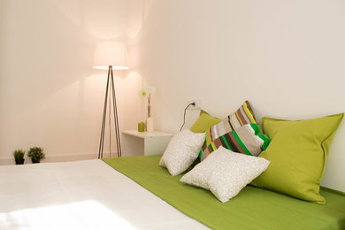 Modelo de dormitorio principal minimalista de tamaño medio sin chimenea con paredes blancas y suelo de madera en tonos medios