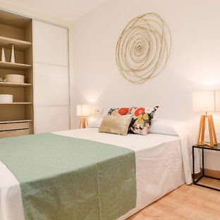 Imagen de dormitorio principal, actual, de tamaño medio, con paredes blancas, suelo beige y suelo de madera clara