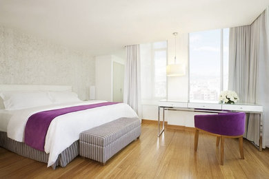 Ejemplo de dormitorio contemporáneo con paredes blancas y suelo de bambú