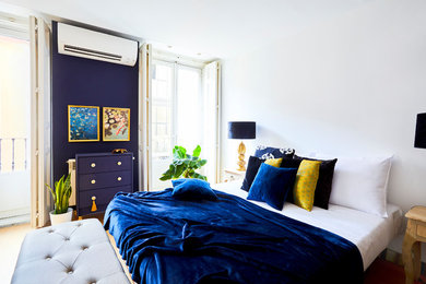 Foto de dormitorio principal tropical de tamaño medio con paredes blancas, suelo laminado y suelo beige