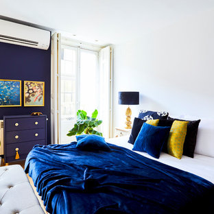 Foto de dormitorio principal, tropical, de tamaño medio, con paredes blancas, suelo laminado y suelo beige
