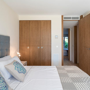 Ejemplo de habitación de invitados mediterránea con paredes blancas, suelo de madera clara y suelo beige