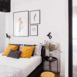 Imagen de dormitorio principal, contemporáneo, pequeño, con paredes blancas, suelo de madera en tonos medios y suelo marrón