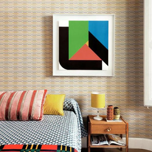 Diseño de dormitorio sin chimenea con paredes multicolor y suelo de madera clara
