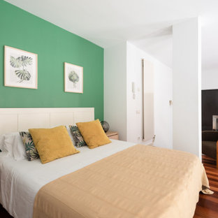 Modelo de dormitorio tipo loft, contemporáneo, con paredes verdes, suelo de madera oscura y suelo marrón