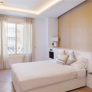Diseño de habitación de invitados actual con paredes blancas, suelo de madera en tonos medios y suelo marrón
