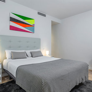 Foto de dormitorio escandinavo con paredes grises y suelo de madera clara