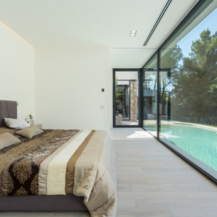 Ejemplo de dormitorio moderno con paredes blancas, suelo de madera clara y suelo beige
