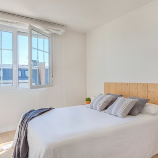 Imagen de dormitorio escandinavo con paredes blancas, suelo de madera clara y suelo beige