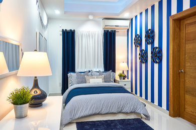 Imagen de dormitorio contemporáneo con paredes multicolor y suelo blanco