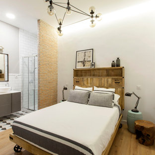 Diseño de habitación de invitados urbana, de tamaño medio, sin chimenea, con paredes azules, suelo de madera en tonos medios y suelo marrón