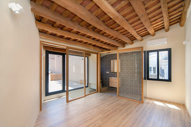 Foto de dormitorio principal mediterráneo de tamaño medio sin chimenea con paredes beige y suelo de madera en tonos medios