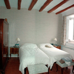 Modelo de dormitorio principal con paredes grises, suelo de baldosas de terracota y suelo rojo