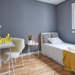 Diseño de dormitorio nórdico con paredes azules, suelo de madera en tonos medios y suelo marrón