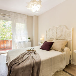 Foto de habitación de invitados actual, pequeña, con suelo laminado, paredes beige y suelo beige