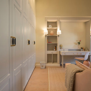 Diseño de dormitorio tradicional renovado, grande, con paredes beige, suelo laminado y suelo marrón
