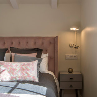 Modelo de dormitorio tradicional renovado, grande, con paredes beige, suelo laminado y suelo rosa