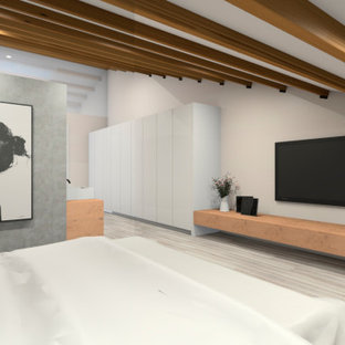Immagine di un'ampia camera da letto stile loft scandinava con pareti beige, pavimento in legno massello medio, camino sospeso e pavimento grigio