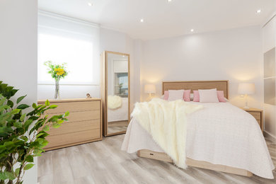 他の地域にあるコンテンポラリースタイルのおしゃれな主寝室 (白い壁、淡色無垢フローリング、ベージュの床) のインテリア