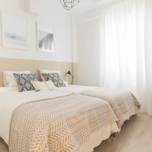 Diseño de dormitorio contemporáneo, sin chimenea, con paredes beige y suelo de madera clara