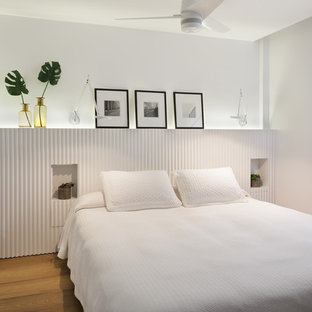 Diseño de habitación de invitados marinera con paredes blancas, suelo de madera en tonos medios y suelo beige