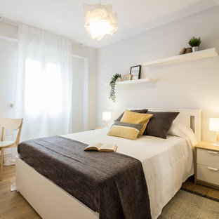Diseño de dormitorio principal, escandinavo, sin chimenea, con paredes grises, suelo marrón y suelo laminado