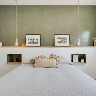 Immagine di una camera da letto design con pareti verdi, parquet chiaro e pavimento beige