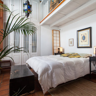 Diseño de dormitorio tipo loft, tropical, de tamaño medio, sin chimenea, con paredes blancas y suelo de baldosas de terracota