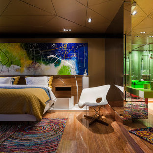 Modelo de dormitorio principal, actual, grande, con suelo de madera en tonos medios, suelo marrón y paredes marrones
