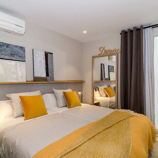 Foto de habitación de invitados costera con paredes blancas, moqueta y suelo beige