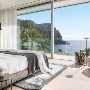 Imagen de dormitorio contemporáneo con paredes grises, suelo de madera clara y suelo beige