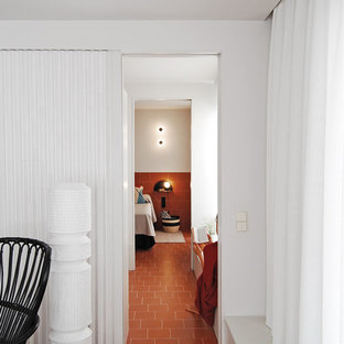 Diseño de dormitorio principal, minimalista, de tamaño medio, sin chimenea, con paredes blancas, suelo de baldosas de terracota y suelo marrón