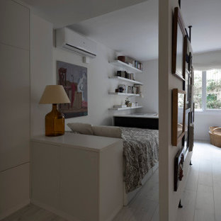 Diseño de dormitorio tipo loft, contemporáneo, pequeño, con paredes blancas, suelo de madera clara y suelo blanco