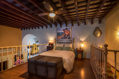 Foto de dormitorio tipo loft de estilo de casa de campo de tamaño medio sin chimenea con paredes multicolor y suelo de madera oscura