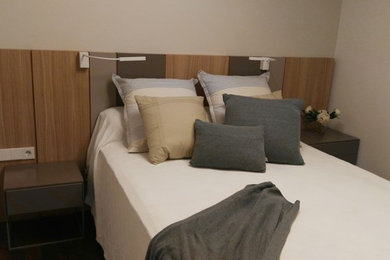 Diseño de habitación de invitados moderna pequeña con paredes grises y suelo de madera oscura
