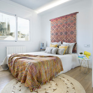 Ejemplo de dormitorio principal, contemporáneo, de tamaño medio, sin chimenea, con paredes blancas, suelo de madera en tonos medios y suelo marrón
