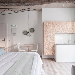 Aménagement d'une chambre mansardée ou avec mezzanine scandinave de taille moyenne avec un mur multicolore, un sol en bois clair et aucune cheminée.