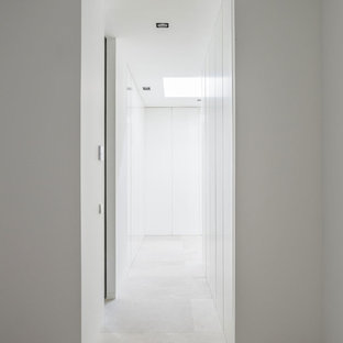 Foto de dormitorio principal, contemporáneo, con paredes blancas, suelo de piedra caliza y suelo beige