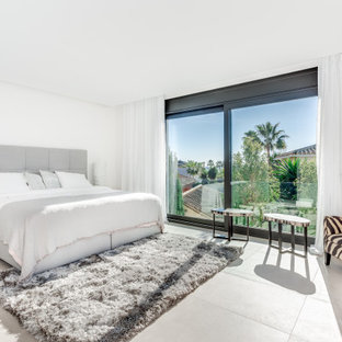 Foto de dormitorio contemporáneo con paredes blancas y suelo gris