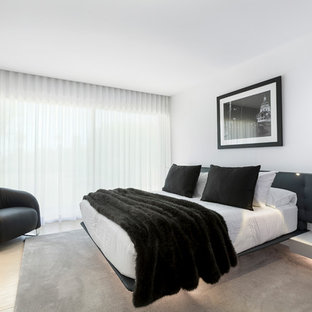 Foto de dormitorio contemporáneo con paredes blancas y suelo beige