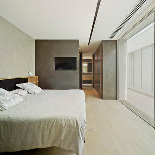 Modelo de dormitorio minimalista, grande, con paredes grises, suelo de madera clara y suelo beige