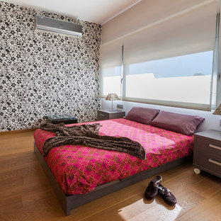 Ejemplo de habitación de invitados contemporánea, grande, sin chimenea, con paredes multicolor, suelo de madera en tonos medios y suelo marrón