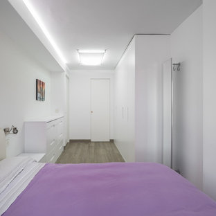 Foto di una camera matrimoniale contemporanea di medie dimensioni con pareti bianche, pavimento in legno massello medio e nessun camino